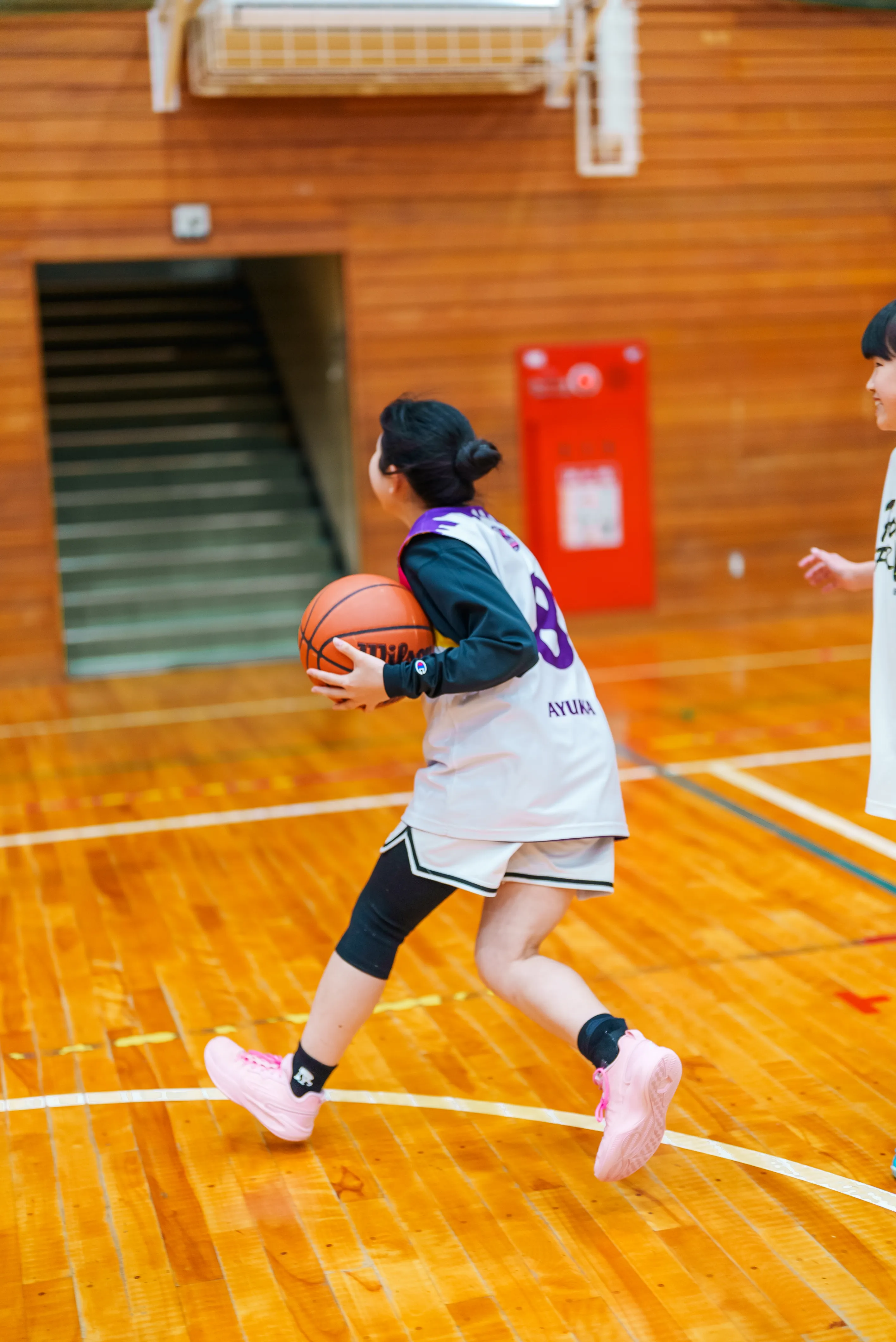 練習中、ボールを手に走る選手の後ろ姿