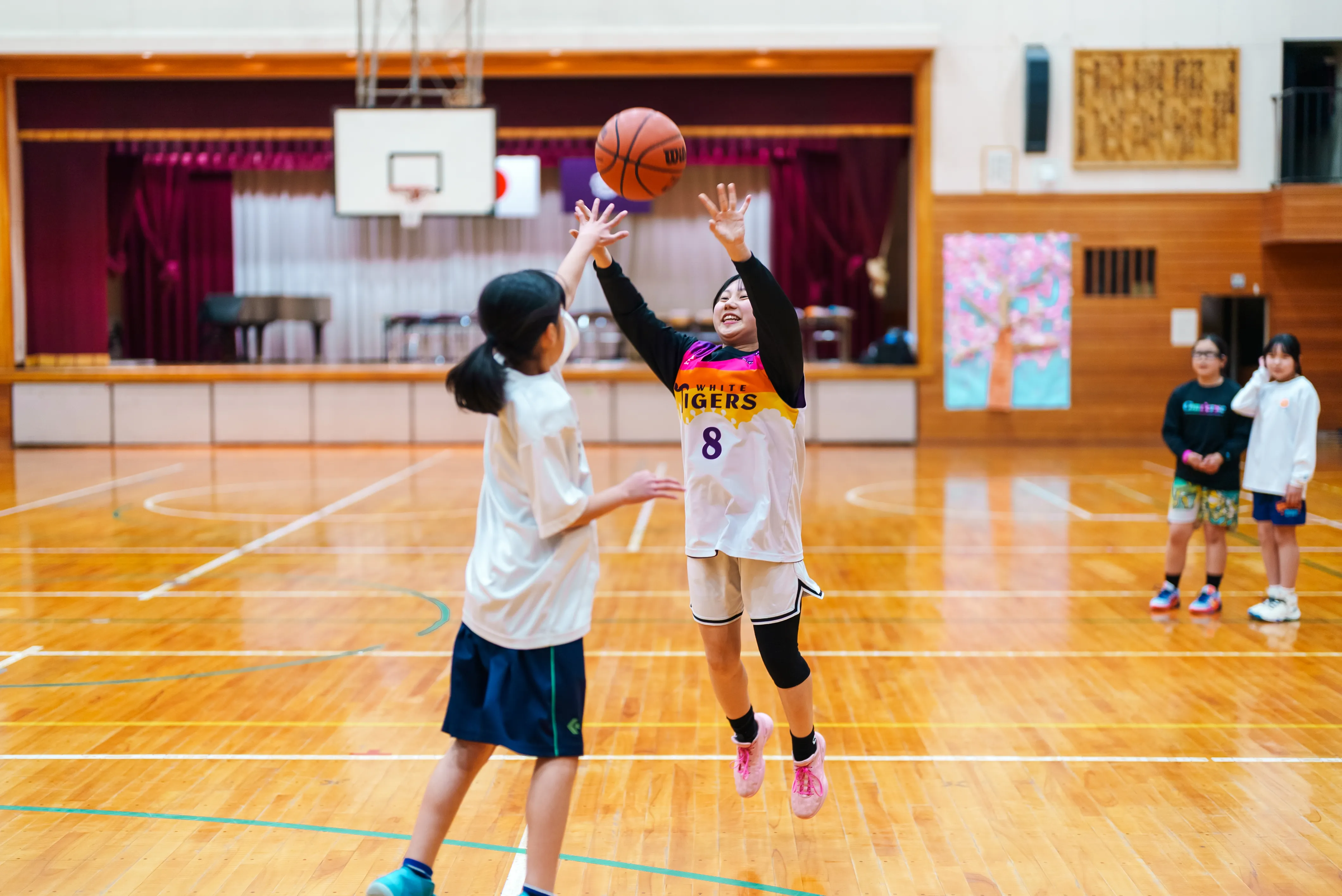 練習中、ジャンプしてシュートに向かう選手
